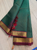 Forest green Kanchipuram saree with gold zari buttas and a rich maroon border
