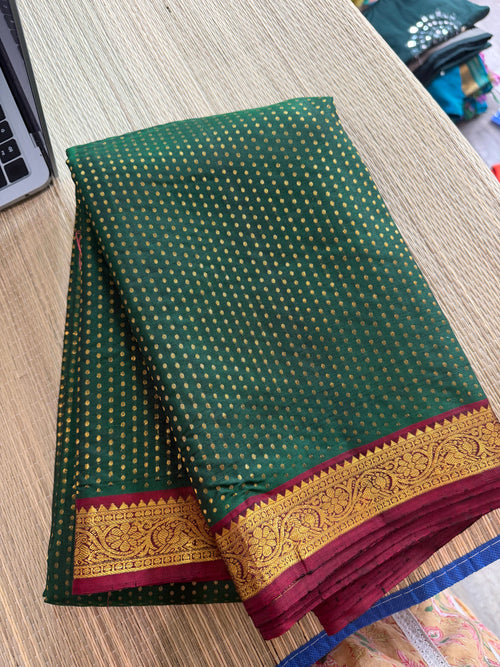 Forest green Kanchipuram saree with gold zari buttas and a rich maroon border